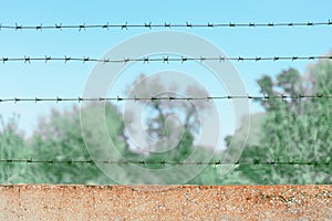 Rows of barbed wire over a wall