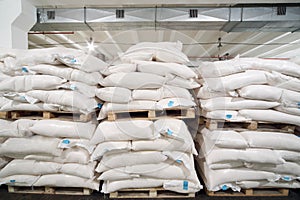 Rows of big white sacks at large warehouse