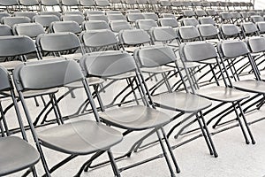 Rows of black folding chairs empty
