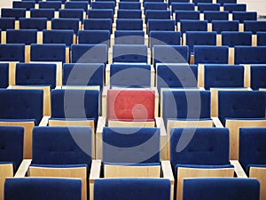 Rows Of Blue Armchairs And One Red