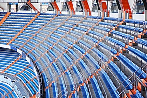 Rows of blue grandstand for fans at football stadium.