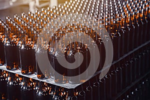 Rows of brown glass beer bottles on the stack. Rows of brown glass.