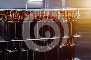 Rows of brown glass beer bottles on the stack. Rows of brown glass.