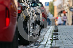 Rows of cars parked along the roadside in crowded city