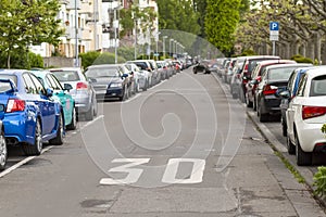 Rows of cars parked on the roadside in residential district
