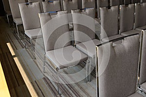 Rows of chairs near window in conference hall