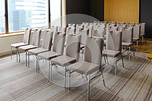 Rows of chairs near window in conference hall