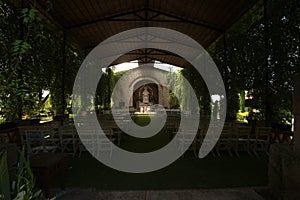 Rows of chairs at an outdoor wedding ceremony, Mexican hacienda oudoor chapel