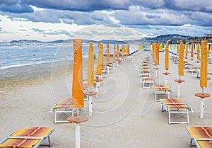 Rows of closed umbrellas and deckchairs on the empty beach