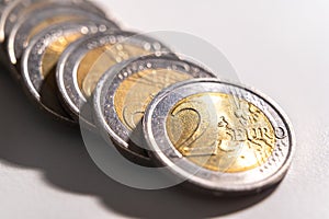 Rows of coins on white surface.