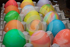 Rows of colored easter eggs in an egg carton