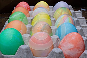 Rows of colored easter eggs in an egg carton