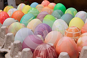 Rows of colored easter eggs in an egg carton