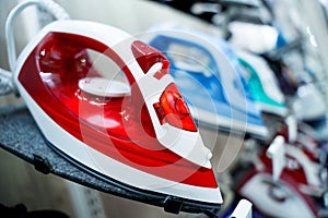 Rows of colored electric irons at the showroom of a large store