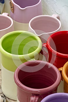 Rows with colorful glazed ceramic jars, flower pots, vases for s