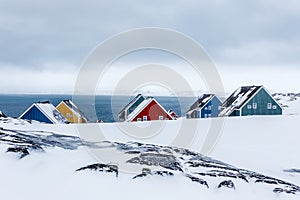 Rows of colorful inuit houses among rocks in a suburb of arctic