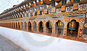 Rows of colorful religious prayer wheels in Paro Rinpung Dzong.