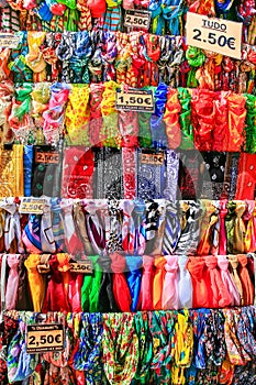 Rows of colorful scarves hang at market photo