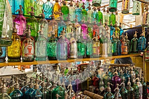 Rows of coloured glass antique soda bottles lined up at a flea market in San Telmo, Buenos Aires, Argentina