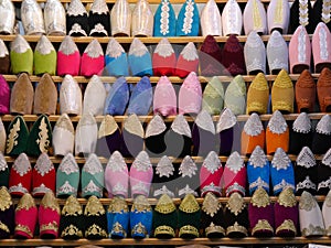Rows of colourful, handmade babouche slippers on sale in souk, Morocco