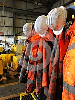 Rows of dirty hi viz clothing and safety helmets