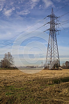 Rows of electricity pylons and power lines over cultivated fields on a winter day in the italian countryside