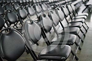 Rows of empty black folding chairs