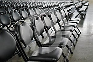 Rows of empty black folding chairs