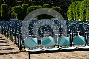 Rows of empty chairs in the garden. Wedding ceremony preparation.