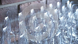 Rows of empty glass goblets on a brick wall background