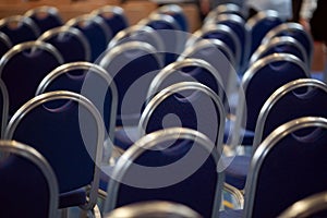 Rows of empty metal chairs in a large assembly hall.Empty chairs in conference hall.Interior meeting room. Back view