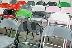 Rows of empty multicolor seats, chairs in auditorium, hall, classroom. Conference hall or seminar room. Selective focus.