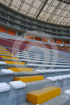 Rows of empty orange and white seats in the sports complex of the Estadio Nacional - Soccer Stadium - in Lima Peru photo