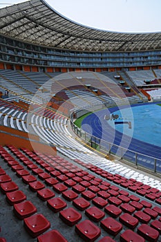 Rows of empty orange and white seats in the sports complex of the Estadio Nacional - Soccer Stadium - in Lima Peru photo