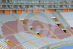 Rows of empty orange and white seats in the sports complex of the Estadio Nacional - Soccer Stadium - in Lima Peru