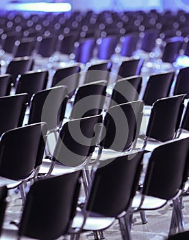 Rows of empty plastic seats in an empty conference room