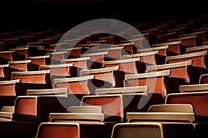 Close-up view of an array of empty red theater seats with a dark background photo