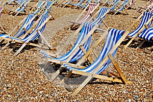 Rows of empty traditional deckchairs on beach