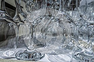 Rows of empty wine glasses close up. Glass goblets on the white table.