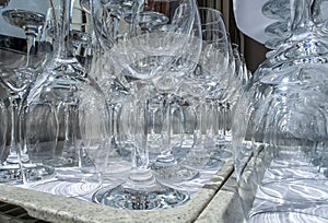 Rows of empty wine glasses close up. Glass goblets on the white table.