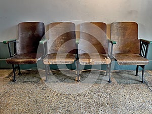 Rows of empty wooden chairs with concrete floor.