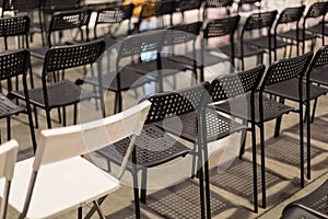 Rows of free chairs in the conference room or meetings. The chairs are black and oin white. Free room