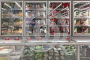 Rows of frozen food refrigeration units in a supermarket. Blurred. Front view