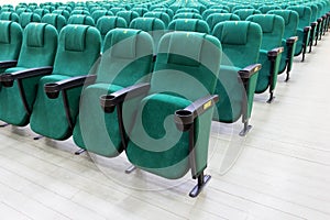 rows of green chairs in the auditorium of a cinema or theater.