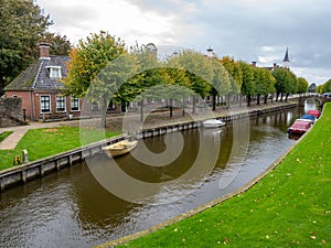 Rows of houses and trees on Lindengracht quay along canal in Sloten, Sleat, Friesland, Netherlands