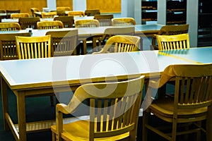 Rows of institutional chairs and tables in learning environment