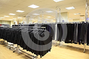 Rows of jackets and men trousers in shop