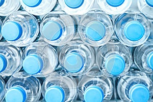 Rows of many transparent plastic bottles with drinking water supply in white refrigerator. Mineral water stack storage in fridge