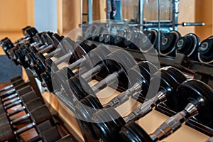 Rows of metal dumbbells on rack in the gym / sport club. Weight Training Equipment. - Image