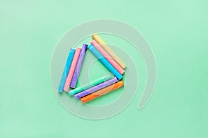 Rows of Multicolored Chalks Crayons Arranged in Triangle on Turquoise Background. Business Creativity Graphic Design Crafts Kids